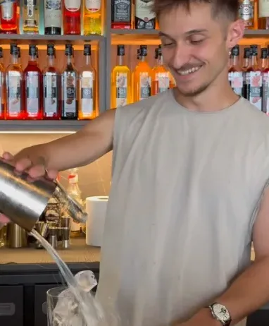 Le barman verse un cocktail derrière le comptoir